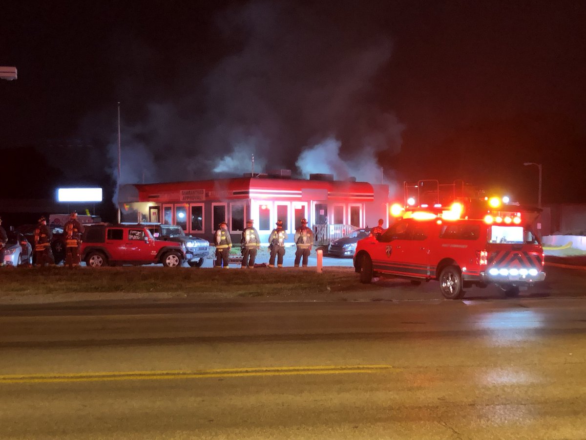 An office building of a used car lot on Washington St near Holt Rd is on fire right now. IFD is currently working to knock down the flames. Washington St is still open, but be very cautious driving near the area